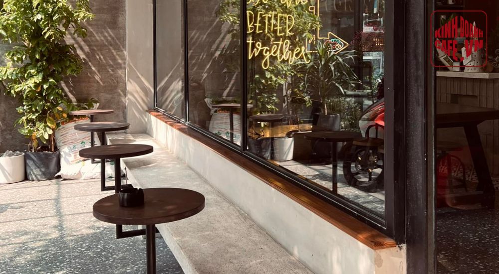 Góc quán cafe không gian mở với bàn gỗ và ánh nắng tự nhiên