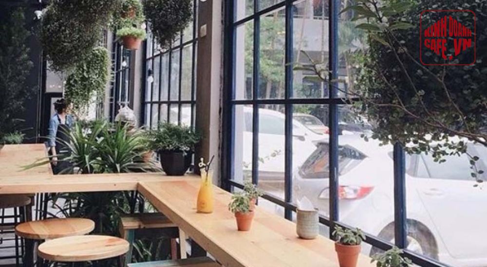 Cửa kính lớn giúp thiết kế quán cafe mặt tiền 5m mở rộng tầm nhìn và đón sáng tự nhiên